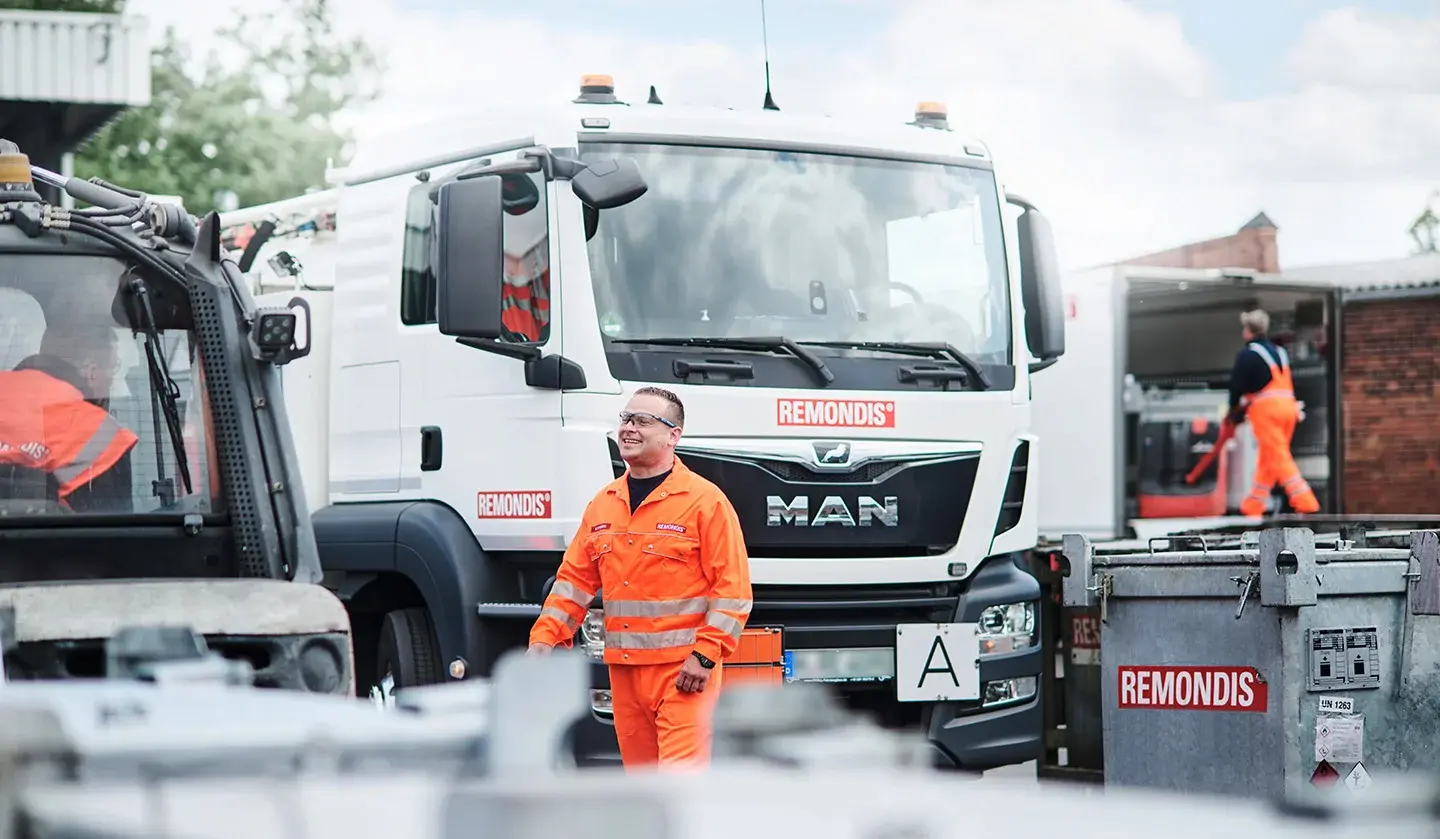 Tre dipendenti stanno caricando un camion con un carrello elevatore e un transpallet.