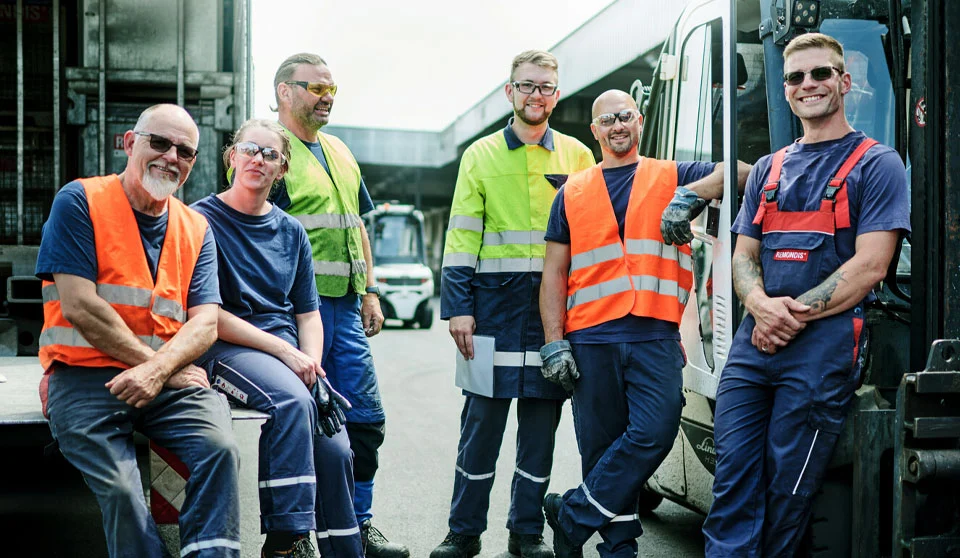 Gruppo di dipendenti in abiti da lavoro in un centro di riciclaggio